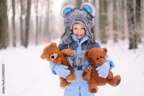 Happy child in winter, having fun with snow.
