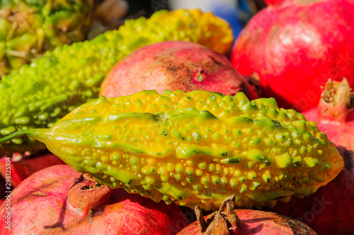 Fresh yellow Kiwano fruits and red pomegranates in autumn photo