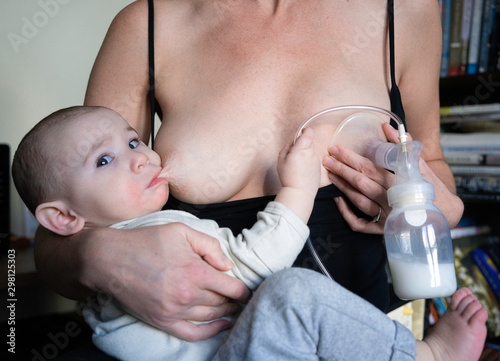 Mother Pumps Milk While Breastfeeding Her Baby photo