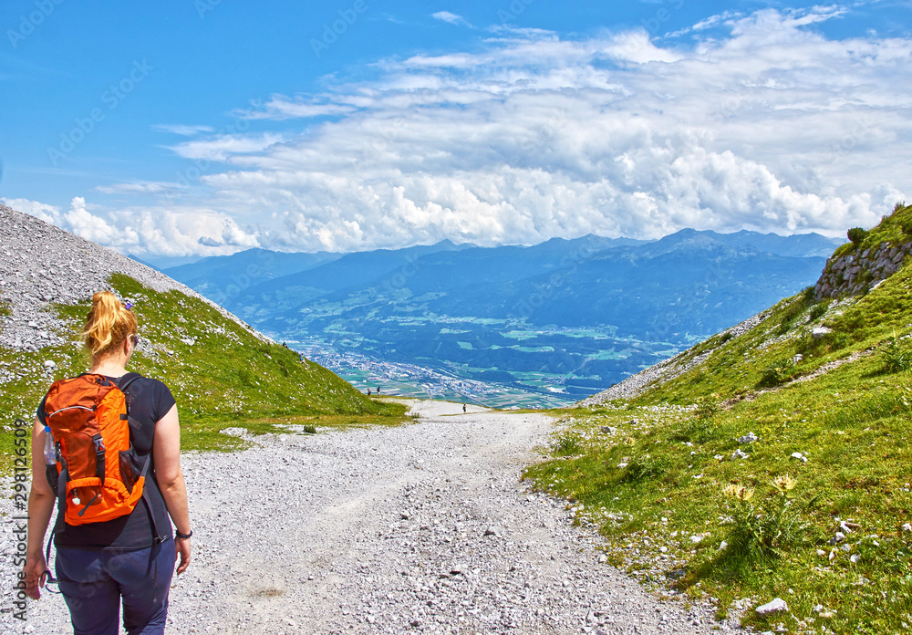 Hiker with backpack on top of the mountain. Girl, Austrian Alps.	