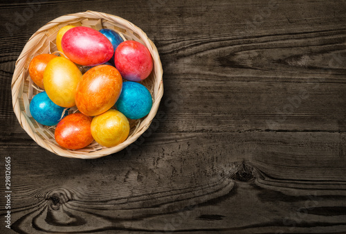 Colored Easter eggs in a basket on a white background.