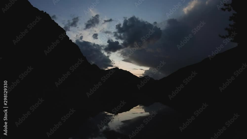 Timelapse of cloudy night sunset over a beautiful mountain lake, reflection of mountains and clouds, fog on water. 4k footage. Timelapse of cloudy night sunset over a beautiful mountain lake, reflection of mountains and clouds, fog on water. 4k footage.