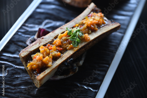 Close up of grilled vegetables and bone marrow on plate photo