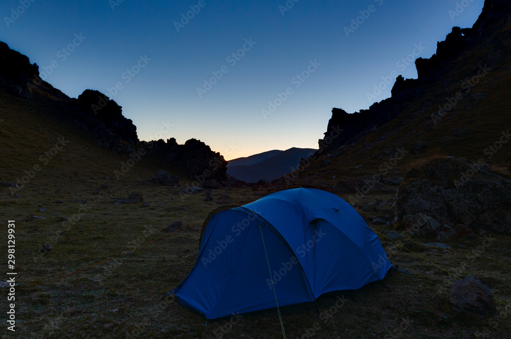 Tourist tent in the mountains during evening twilight. North Caucasus.