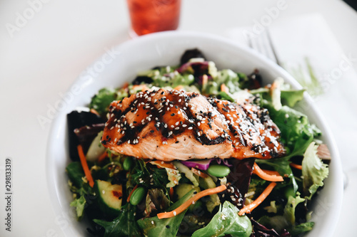 Close up of salad with grilled salmon served in bowl