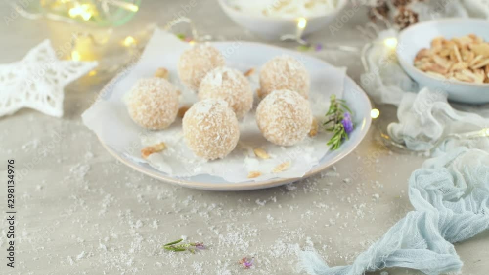 Homemade candies with coconut roasted almonds on a Christmas season table decorated with lights and stars. Homemade candies with coconut roasted almonds on a Christmas season table decorated with lights and stars.