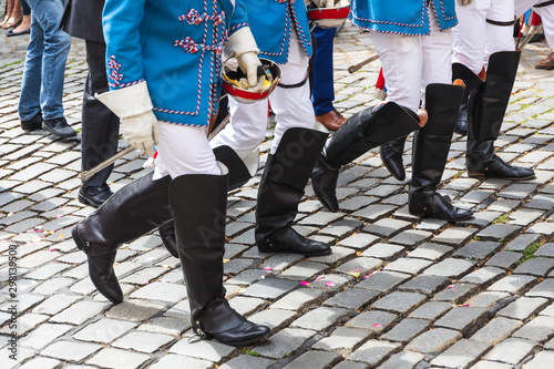 Close-up of boots of members of student fraternity in uniform walking on cobbled street photo