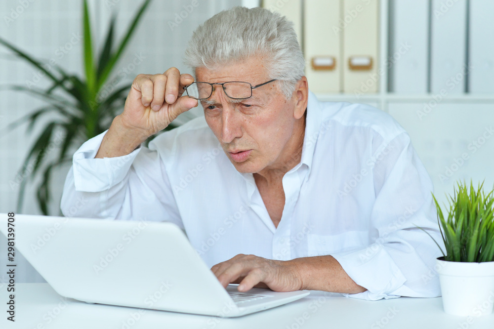 Close up portrait of surprised senior man looking at laptop Close up portrait of surprised senior man looking at laptop