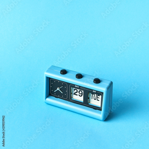 Vintage blue flip clock with calendar on a blue background with copy space. Day TUE, date 29, time is twenty two to five. photo