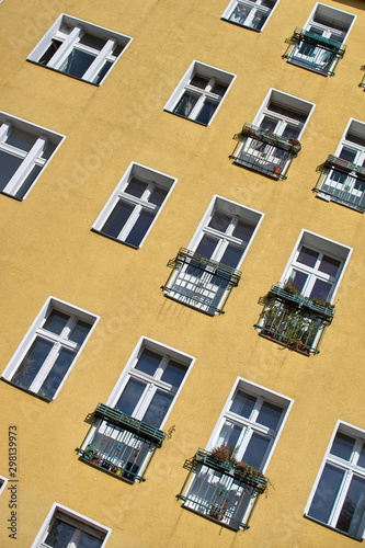 The yellow wall of the house with windows and small balconies. Angle shooting