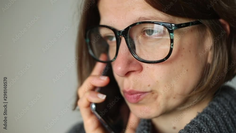 A young woman is talking on a cell phone. The girl speaks on the smartphone. A young woman is talking on a cell phone. The girl speaks on the smartphone.