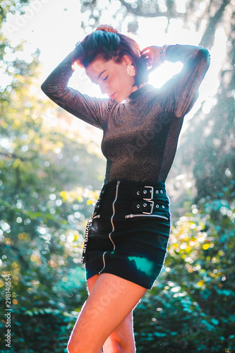Street fashion concept - closeup portrait of a pretty hipster girl. Wearing  modern clothes. Artsy bohemian rock style. Toned style instagram filters in nature background