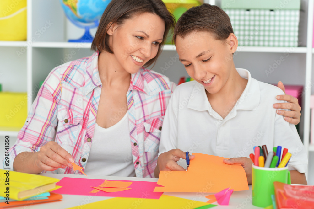 mother and son gluing and cutting colorful paper mother and son gluing and cutting colorful paper