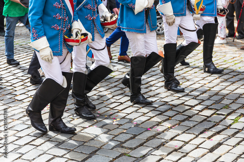 Members of student fraternity in uniform walking on cobbled street