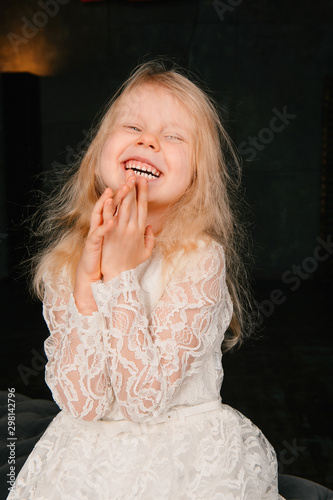 Cute little blond girl emotional portrait against dark background