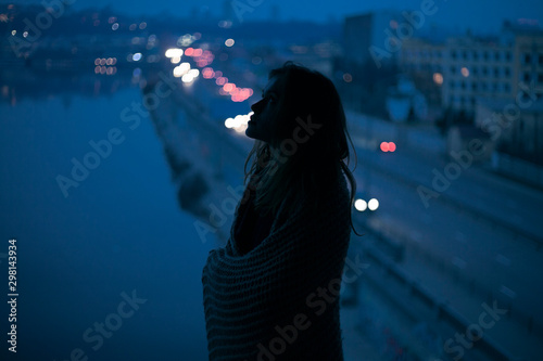 portrait girl silhouette on the background of the city and river in the evening photo