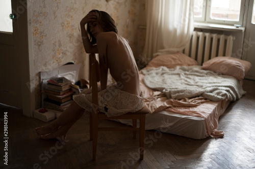 girl in a dress with a bare back sitting on a chair photo