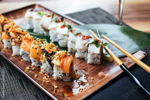 A plate of two sushi rolls with chopsticks photo