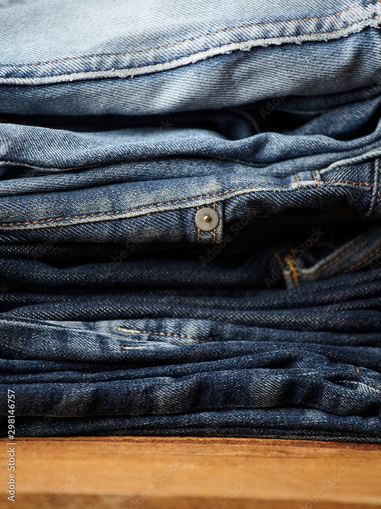 Stack of various blue jeans on black background. Beauty and fashion, clothing concept. Detail of nice blue jeans. Jeans texture or denim background. Collection of jeans. the blue jeans fabric details Stack of various blue jeans on black background. Beauty and fashion, clothing concept. Detail of nice blue jeans. Jeans texture or denim background. Collection of jeans. the blue jeans fabric details