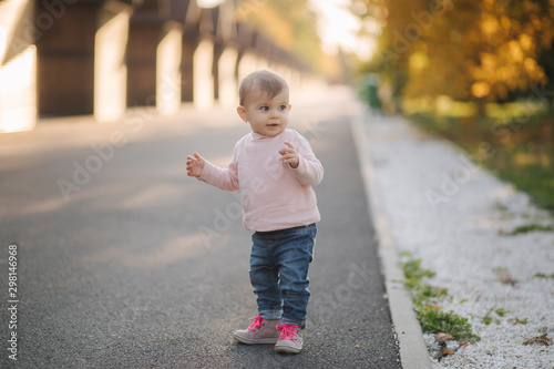 Adorable little girl walk in the parl in october. Cute ten month baby walk. Beautiful happy girl. Autumn mood