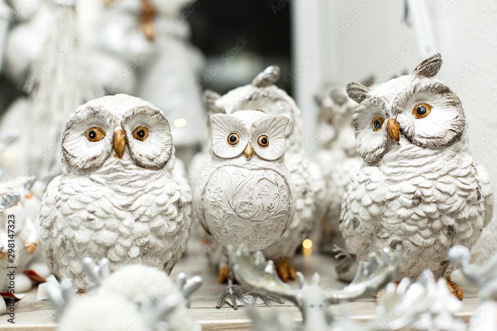 Obraz premium holiday christmas decoration. Shelf with figures of toy white owls. Little things that create a Christmas mood.