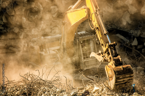 Heavy machinery surrounded with dust  cloud taking down an old building 