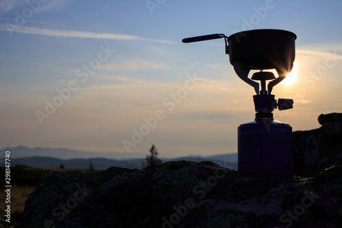 Cooking, brewing tea in the mountains on a portable gas cooker