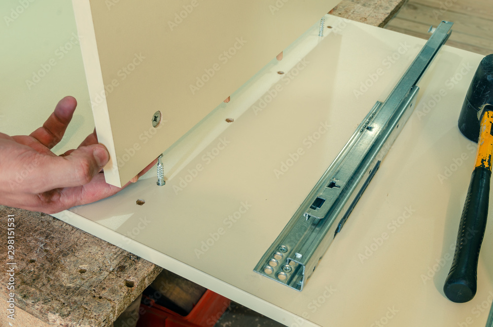 Furniture fittings, wooden dowels, fastener connection on chipboard workpieces, close-up Furniture fittings, wooden dowels, fastener connection on chipboard workpieces, close-up