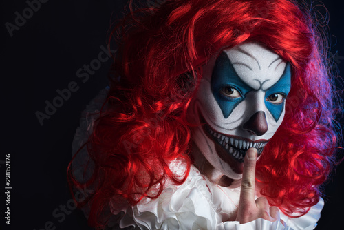 Fototapeta Scary  woman clown with grey background in studio