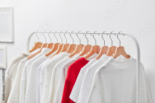 Distinctive red shirt on hangers among white clothes