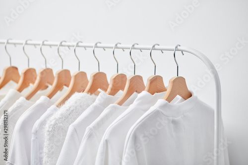 Row of hangers with white clothing photo