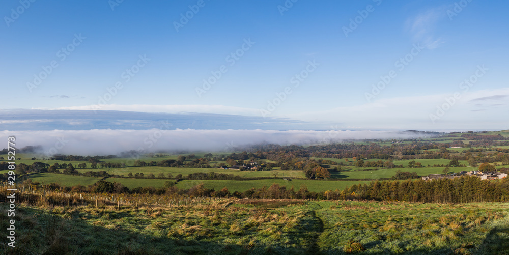 Fototapeta premium Fog and mist roll over the land below Beacon Fell Country Park seen on a cold October morning in 2019.