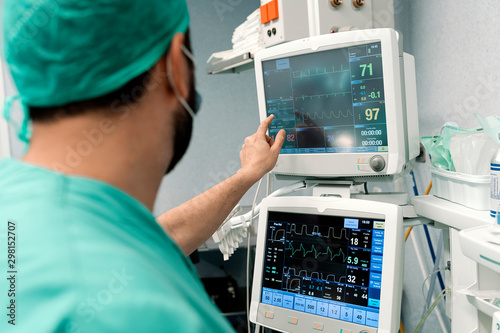 Doctor looking at monitors with pulse of patient