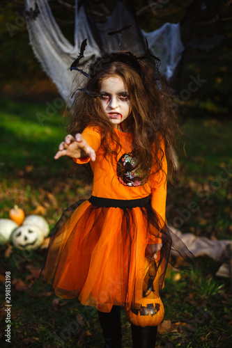 Girl transformed into zombies with a pumpkin in her hands  costume for halloween.