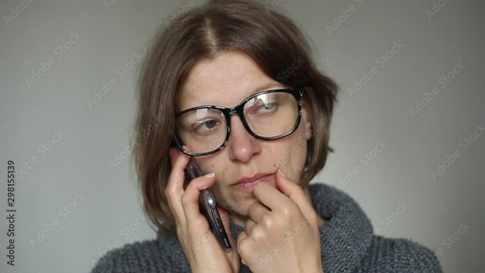 A young woman is talking on a cell phone. The girl speaks on the smartphone. A young woman is talking on a cell phone. The girl speaks on the smartphone.