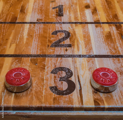 Shuffleboard game and red discs photo