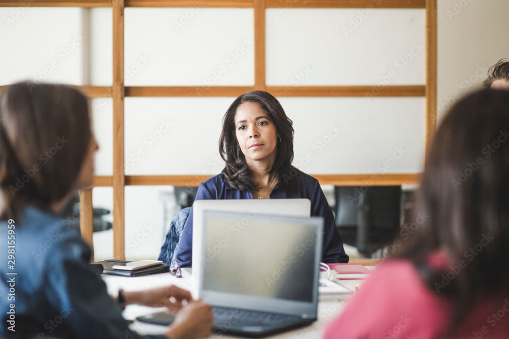 Female colleagues planning strategy while sitting in board room Female colleagues planning strategy while sitting in board room