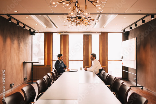 Financial advisor discussing with client in board room at law office photo