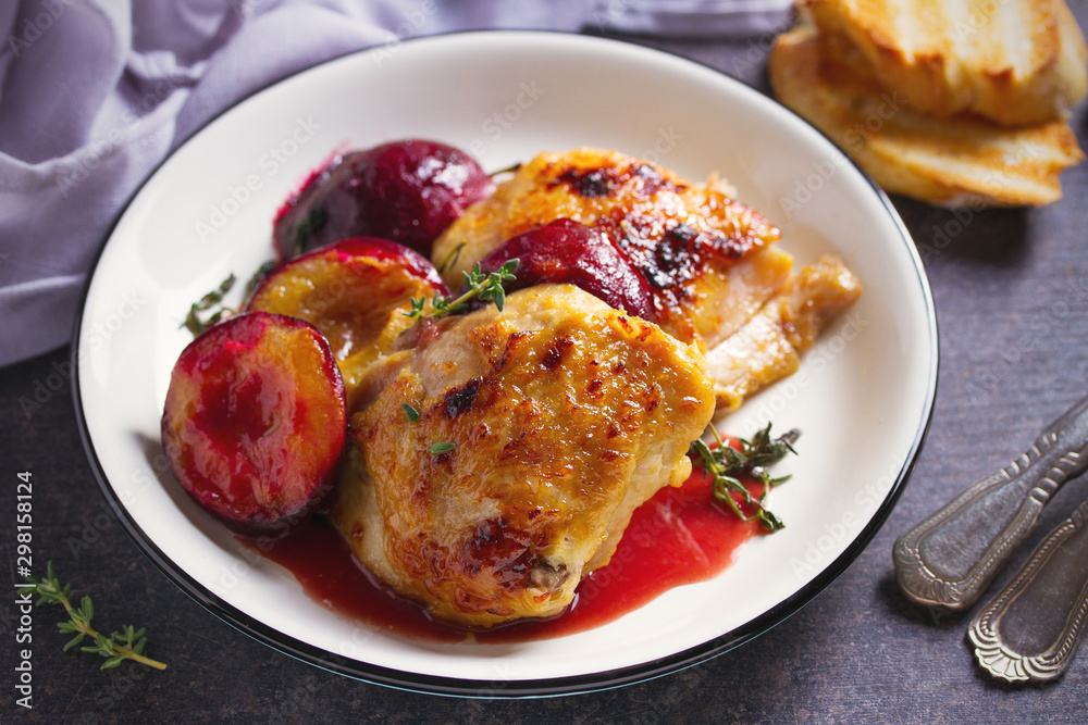 Baked chicken and plums in ginger, honey and red wine sauce with thyme. Horizontal image Baked chicken and plums in ginger, honey and red wine sauce with thyme. Horizontal image