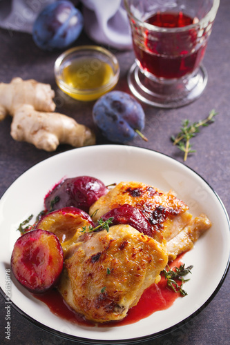 Baked chicken and plums in ginger, honey and red wine sauce with thyme. Vertical image
