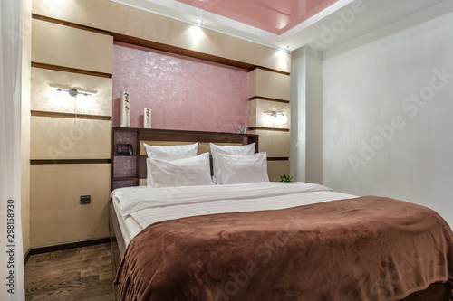 Interior of the modern luxure bedroom in studio apartments in brown and pink light color style