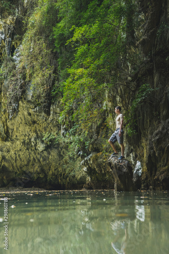 Wallpaper Mural Shirtless man standing on rock in lake by cliffs in Krabi, Thailand Torontodigital.ca