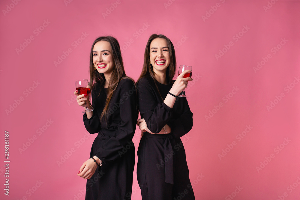 Two women celebrate the New Year party having fun laughing and drinking wine. Two women celebrate the New Year party having fun laughing and drinking wine.