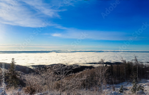 Winter landscape with trees and blue sky. Find a smoking chimney in the clouds. Sljeme, Zagreb, Croatia