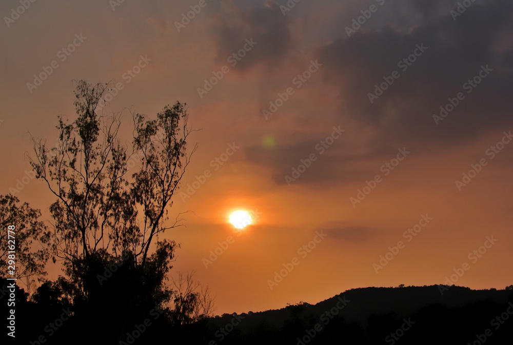 Sunset sky with silhouette of forest tree and mountain