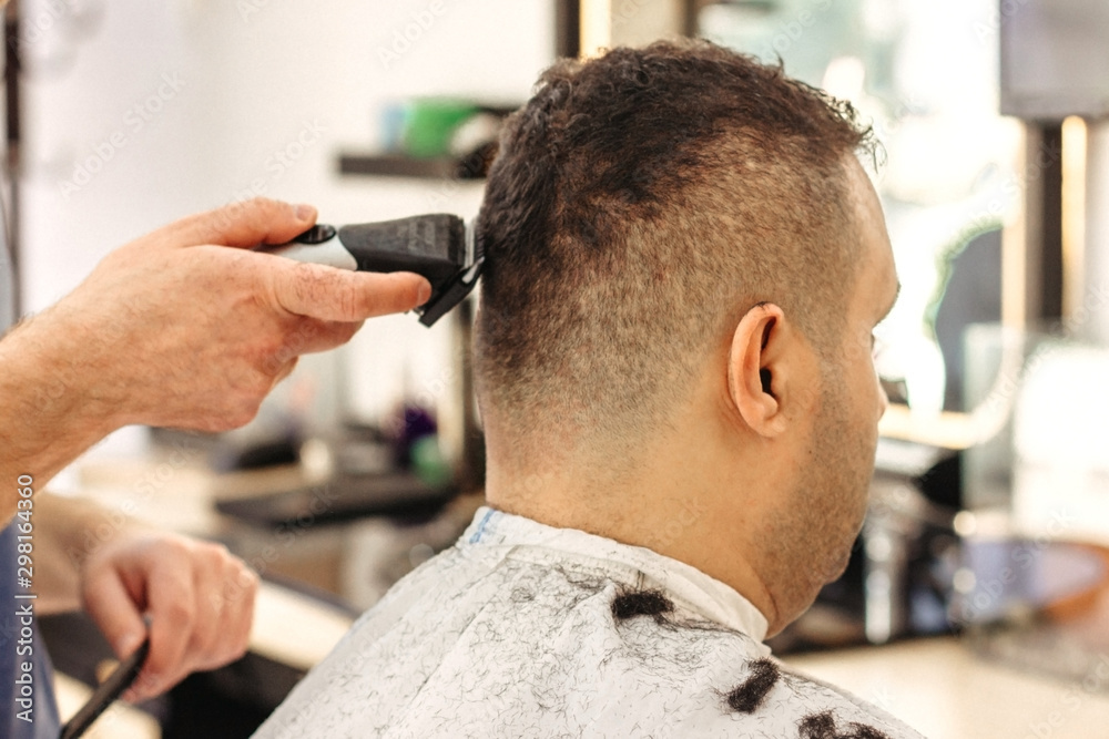 Barber making stylish haircut with professional machine in barber shop. Hair  cut for turkish man Stock Photo | Adobe Stock