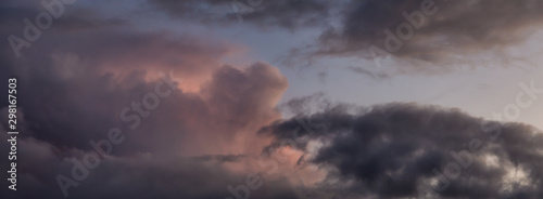 Dramatic Panoramic View of a cloudscape during a dark, rainy and colorful sunset. Taken in Alaska, USA.