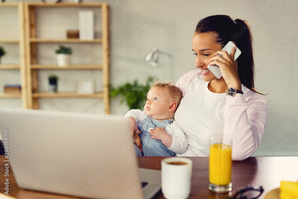 Happy mother talking on the phone while being with her baby at home. Happy mother talking on the phone while being with her baby at home.