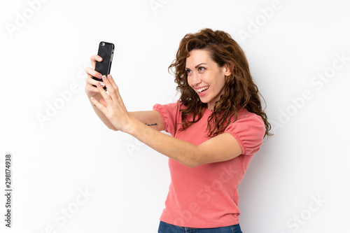 Young pretty woman over isolated background making a selfie