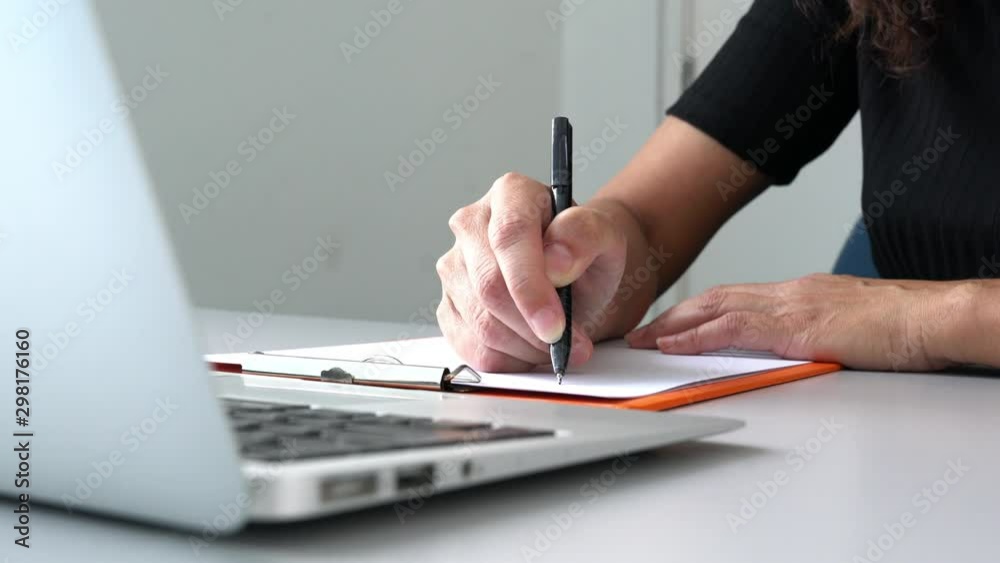 Businesswoman or executive writing on paper in office. Business or work concept. Real time.